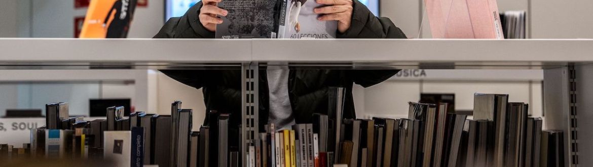 Una persona consultant un llibre a la biblioteca Gabriel Garcia Marquez. © Laura Guerrero